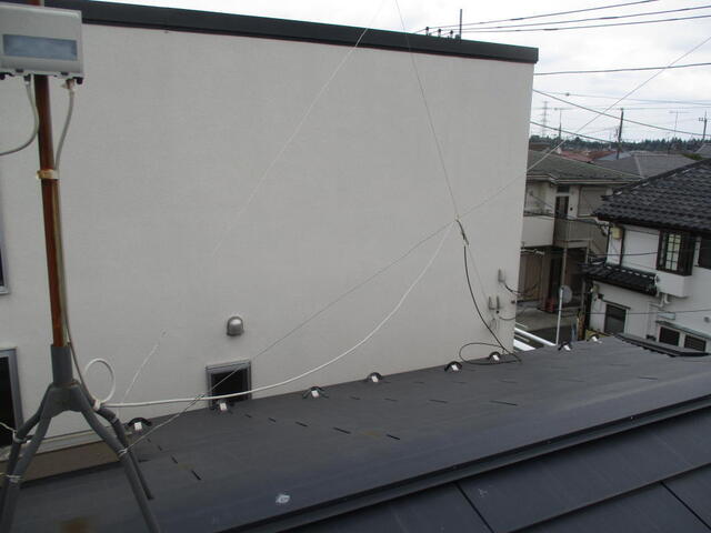屋根上の引き回し配線が悲惨な状況で風で揺れている